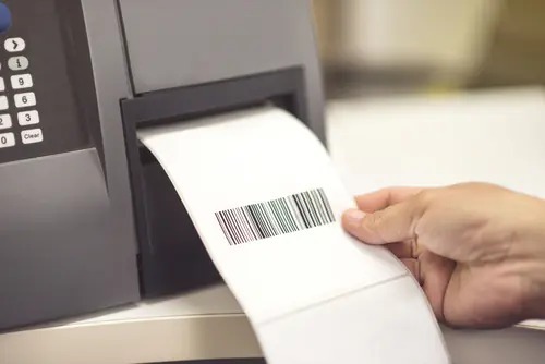 Industrial thermal label printer dispensing a printed barcode label for asset tracking